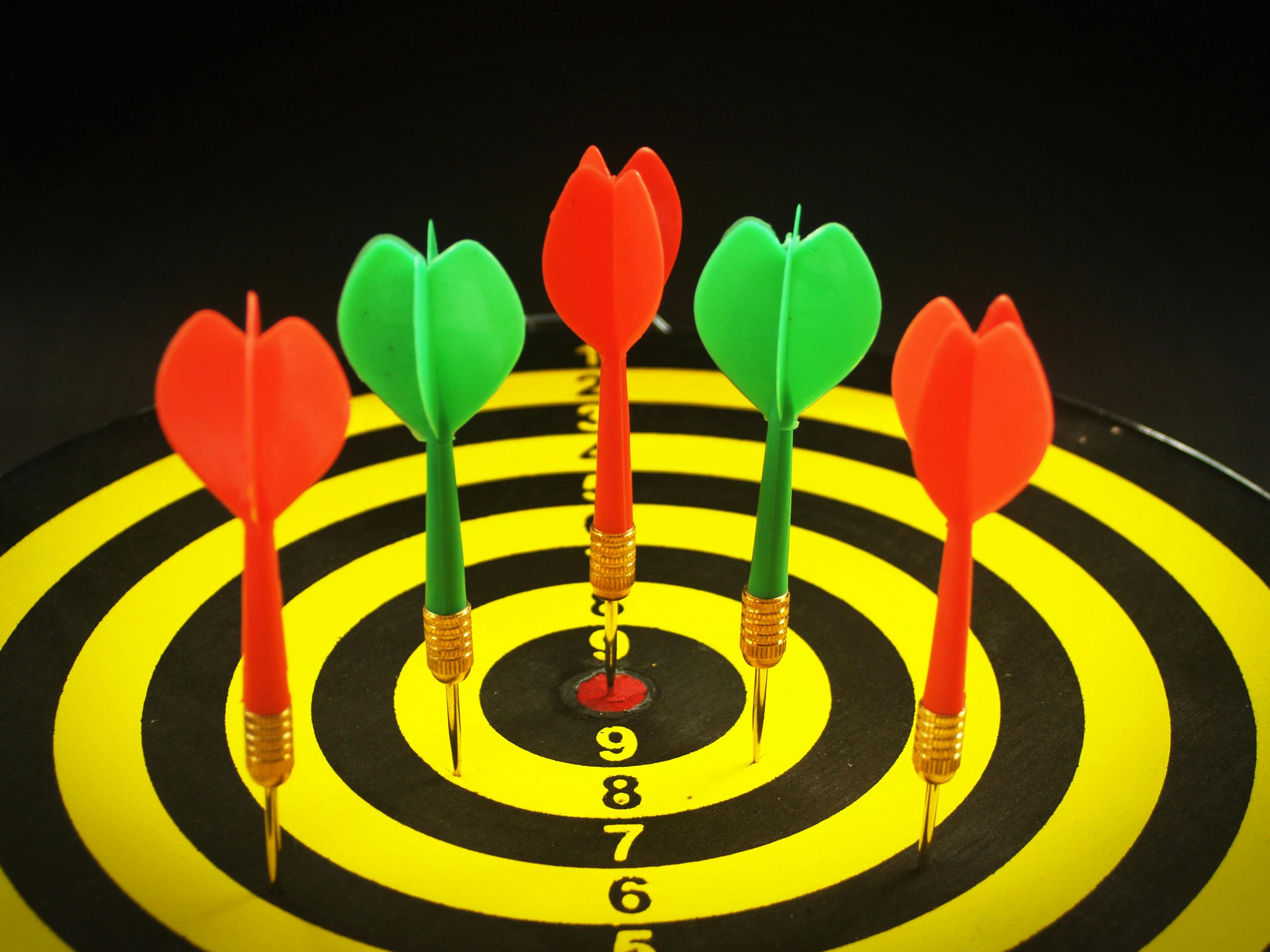 Dartpfeile auf einer Zielscheibe als Symbolbild für Präzision im Darts