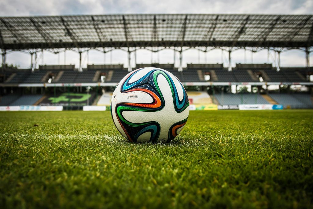 Stadionrasen mit Fußball als Symbolbild zur Premier League